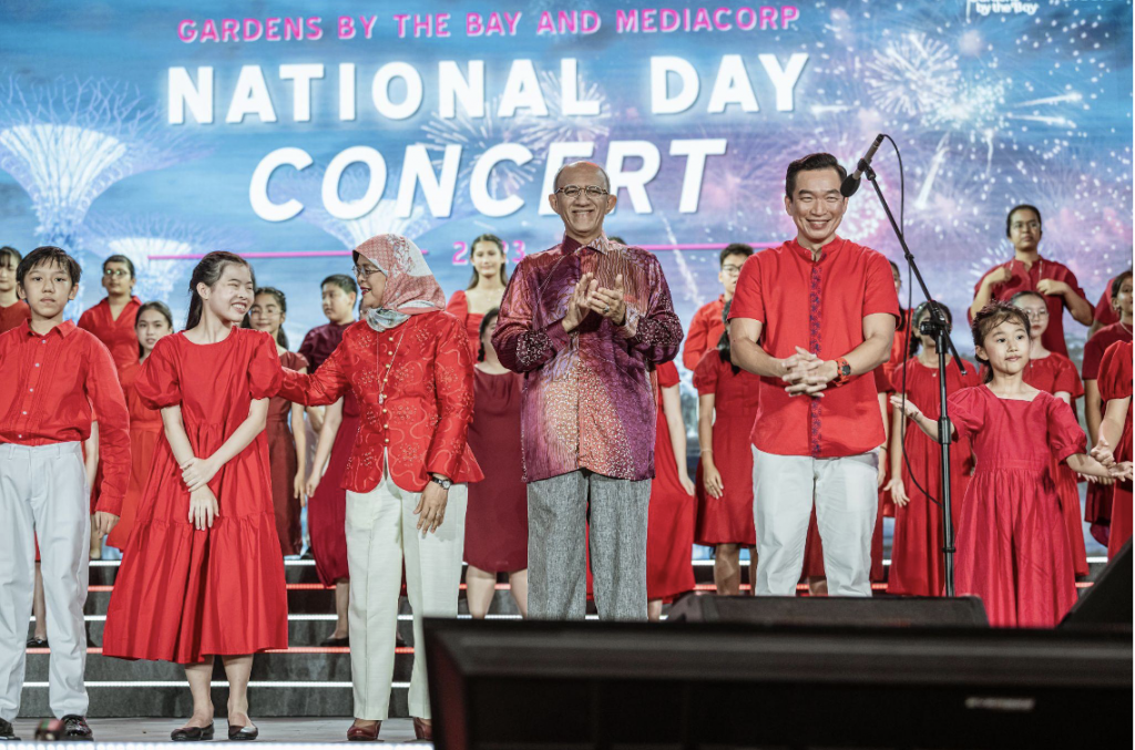 Group photo of President Halimah Yacob and her husband and Senior Parlimentary Secretary Eric Chua on stage.