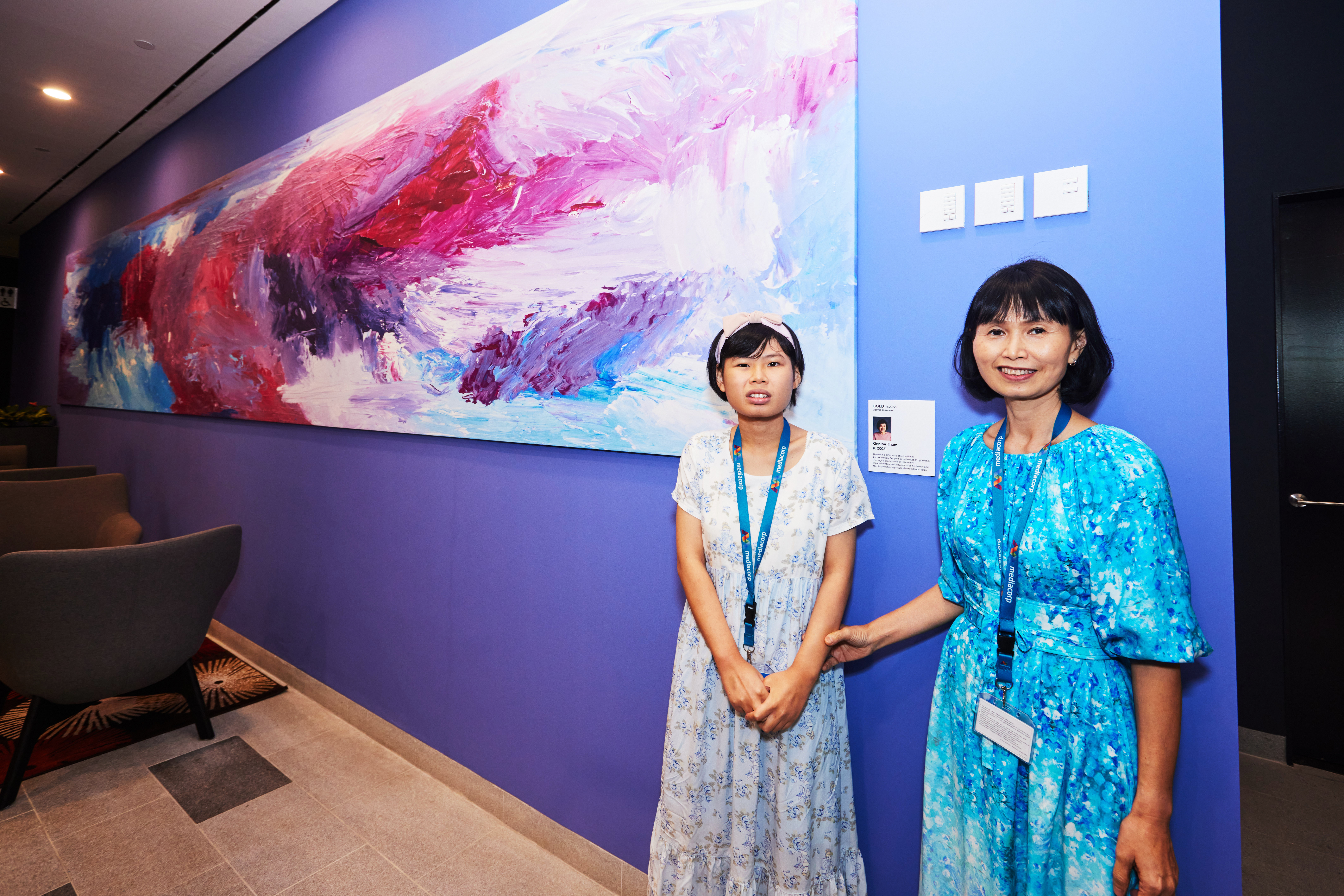 Genine Tham - beneficiary from ExtraOrdinary People, stands with her mother by her remarkable painting titled Bold