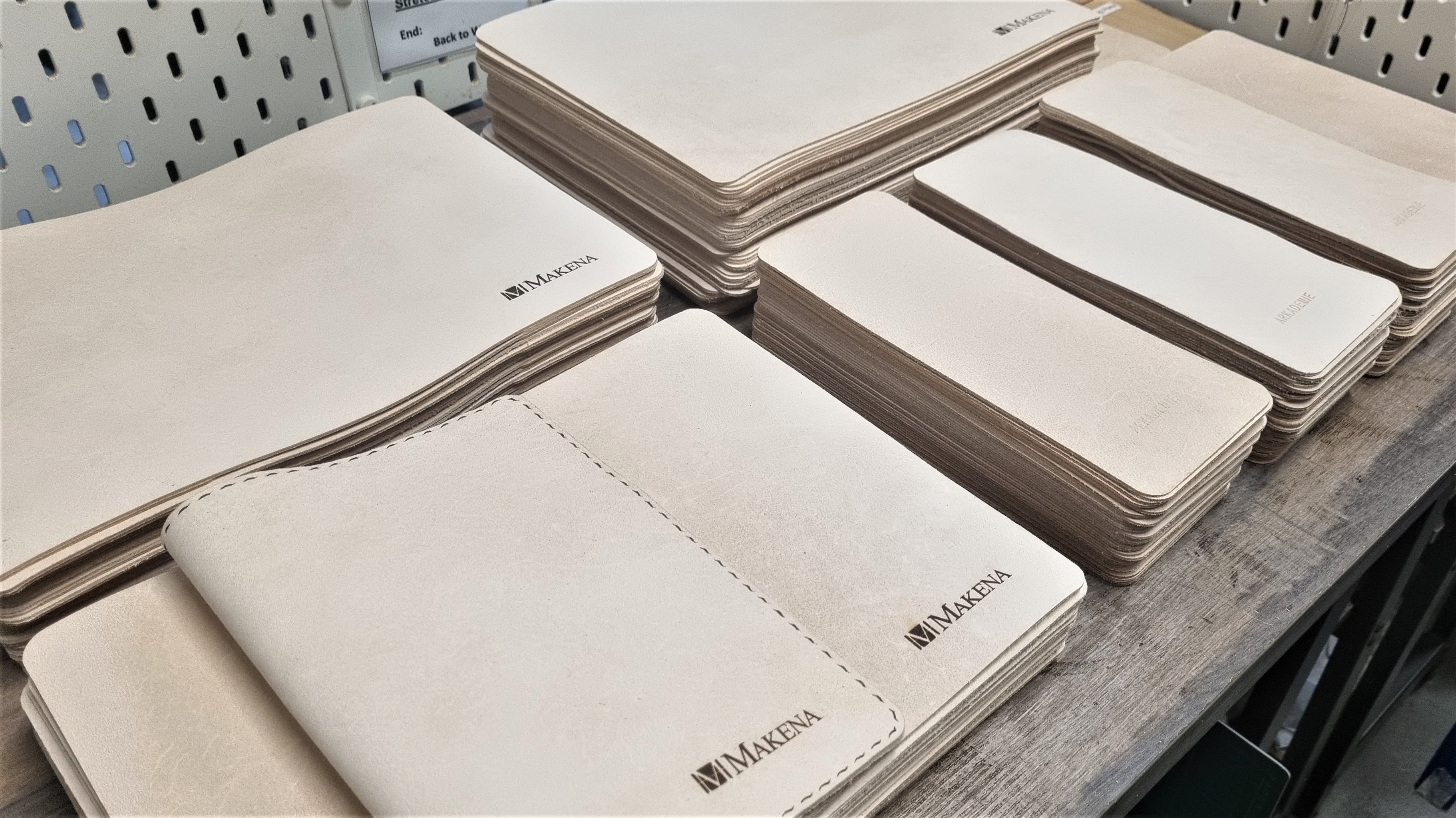 Leather book sleeves with the Makena logo embedded at the bottom right corner of each sleeve.