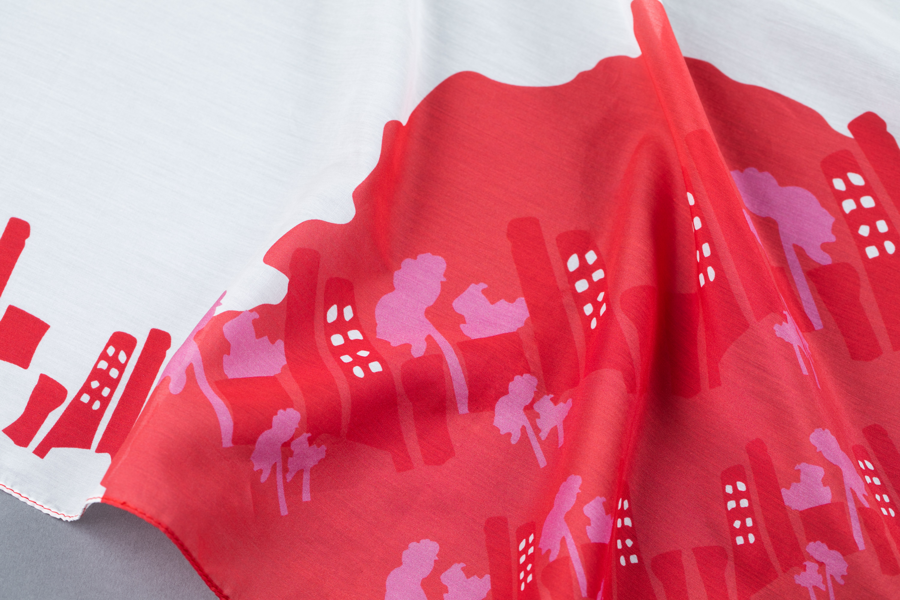 A red and white cotton-silk scarf with building designs.