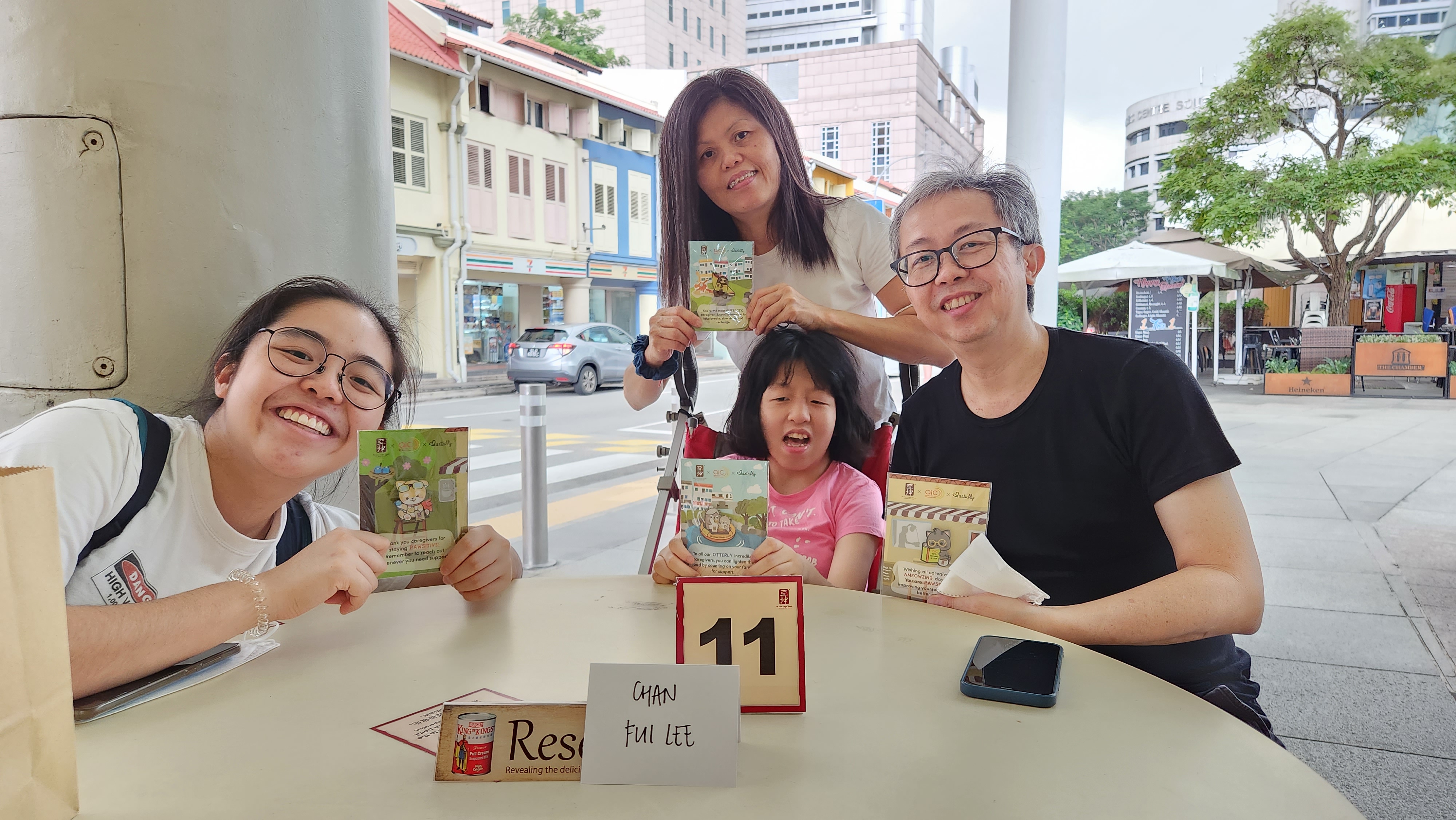 A family with a young girl with disability enjoying Ya Kun together at a Project 3i event.